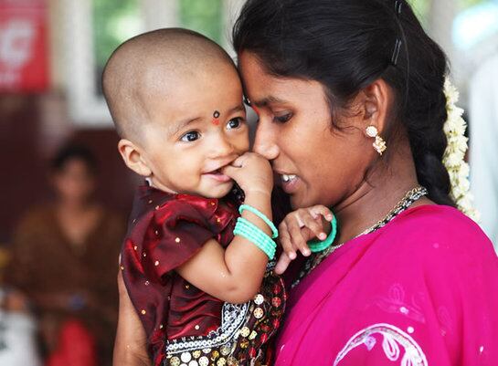 Mujer y niño en la  estación de ferrocarril de Anantapur