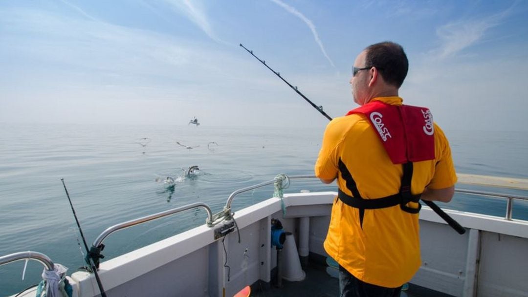 Un hombre pescando desde su embarcación.