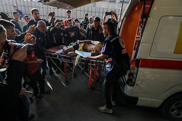 Ciudadanos palestinos socorriendo a los heridos por un tiroteo en Rafah