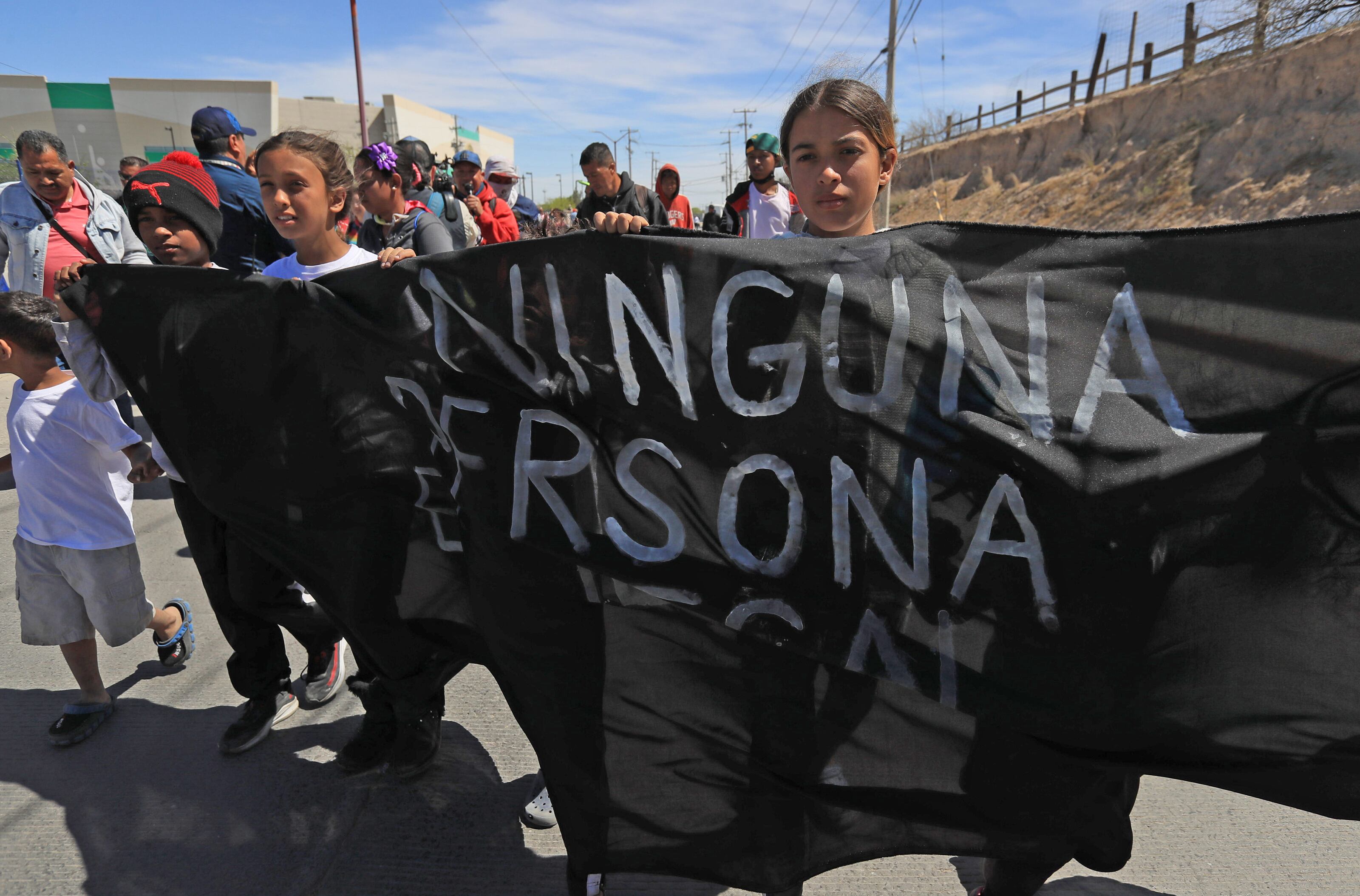 Un grupo de migrantes y activistas protestan durante la llegada del presidente de México Andrés Manuel López Obrador (fuera de cuadro) por los 40 migrantes fallecidos debido a un incendio en un centro migratorio en Ciudad Juárez