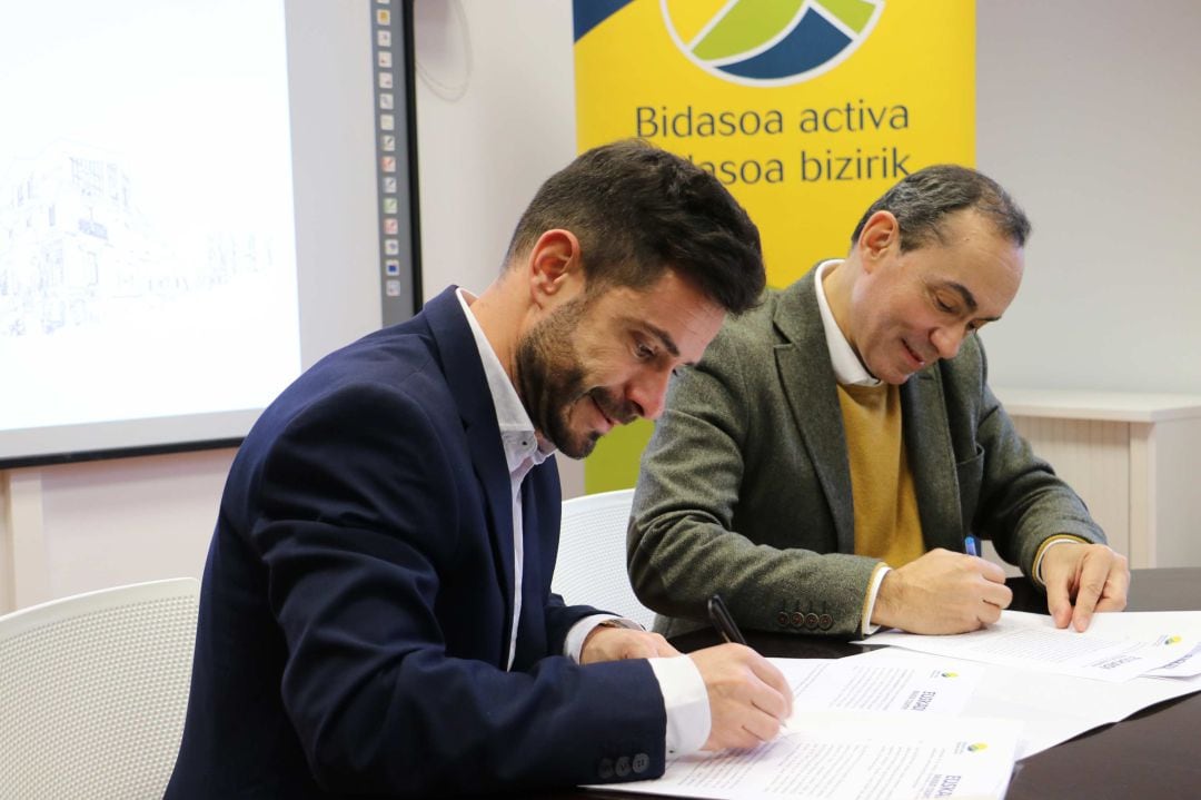 Harkaitz Millán, director general de Basquetour y Miguel Ángel Páez, presidente de Bidasoa Activa, firma el acuerdo de colaboración.