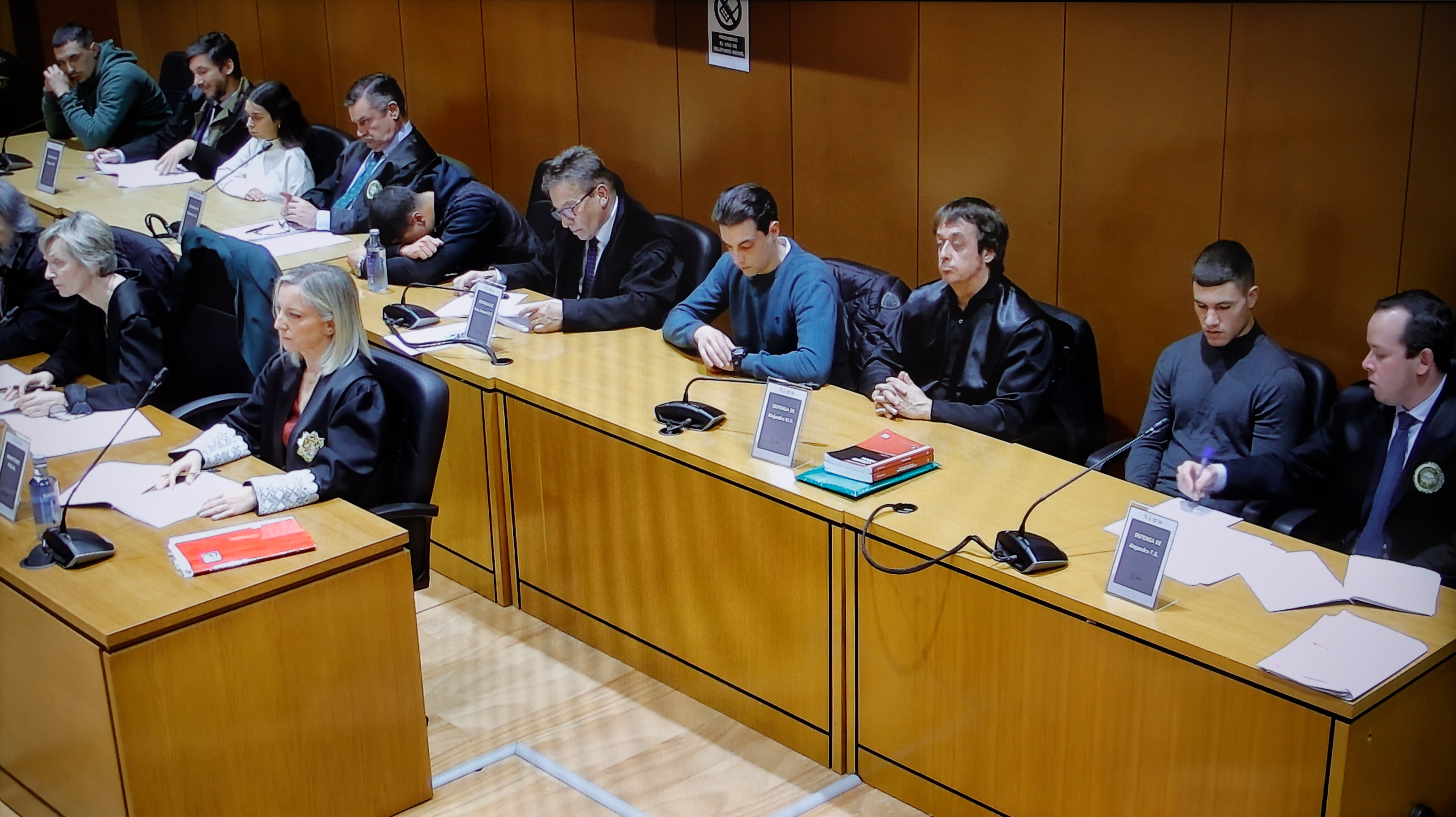 A CORUÑA, 24/11/2024.- Foto tomada a la pantalla de circuito cerrado de la Audiencia Provincial de A Coruña de los cinco acusados por el asesinato del joven brasileño Samuel Luiz, durante la lectura del veredicto celebrada este domingo en la Audiencia Provincial de A Coruña. EFE/Cabalar
