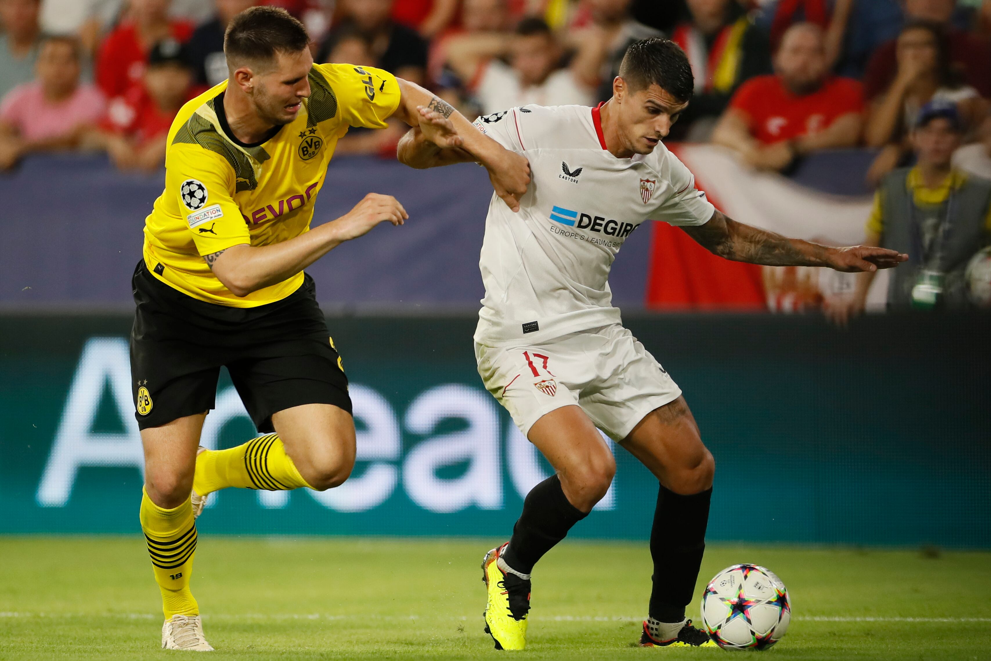 Erik Lamela del Sevilla, y Niklas Süle del Borussia Dortmund, durante el partido de Liga de Campeones en fase de grupos disputado en el estadio Sánchez Pizjuan de Sevilla. EFE/José Manuel Vidal