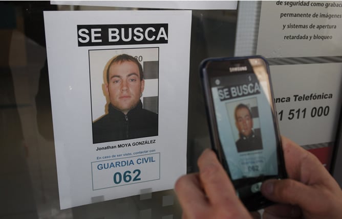 Una persona graba con un móvil uno de los carteles del dispositivo de búsqueda que ha organizado la Guardia Civil para dar con el paradero del supuesto secuestrador de una niña de 16 meses del municipio de Gérgal (Almería)