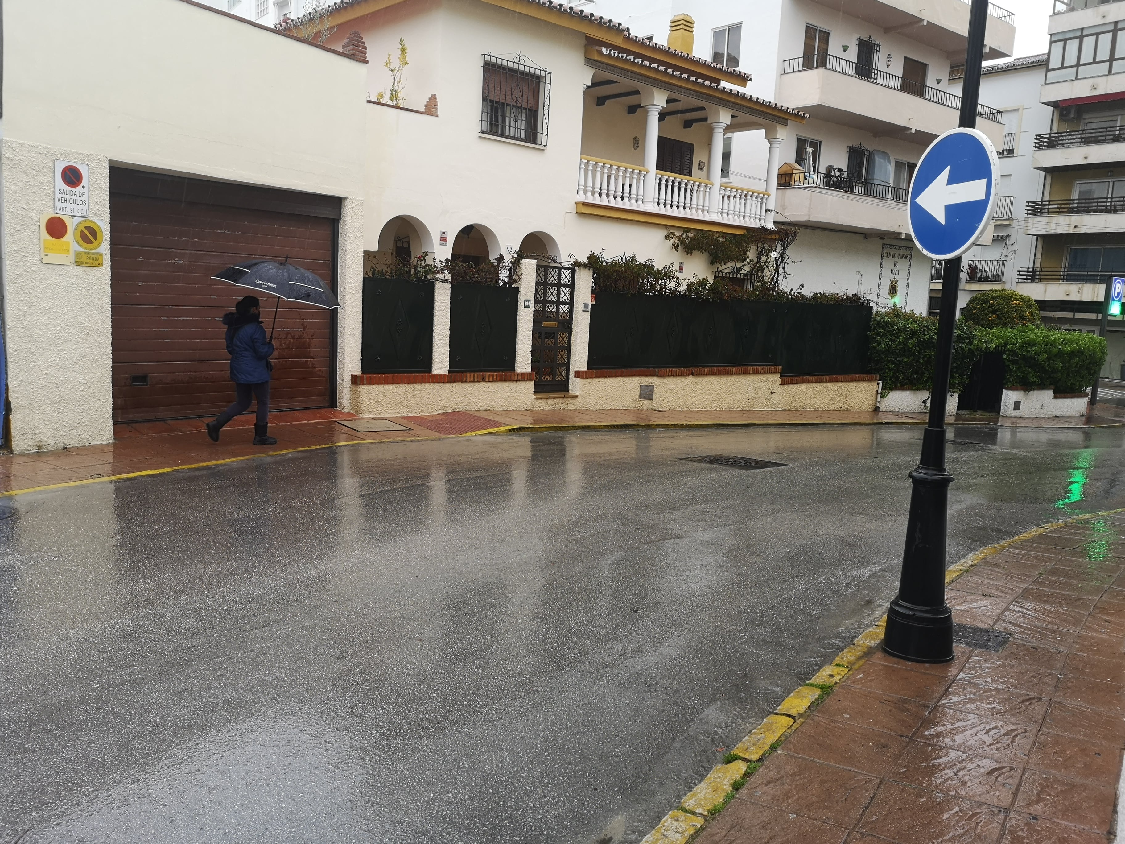 Una ciudadana pasea bajo su paraguas por el centro urbano de Ronda