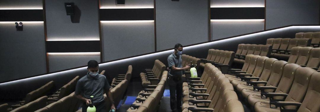 Personal de una sala de cine llevando a cabo las labores de limpieza