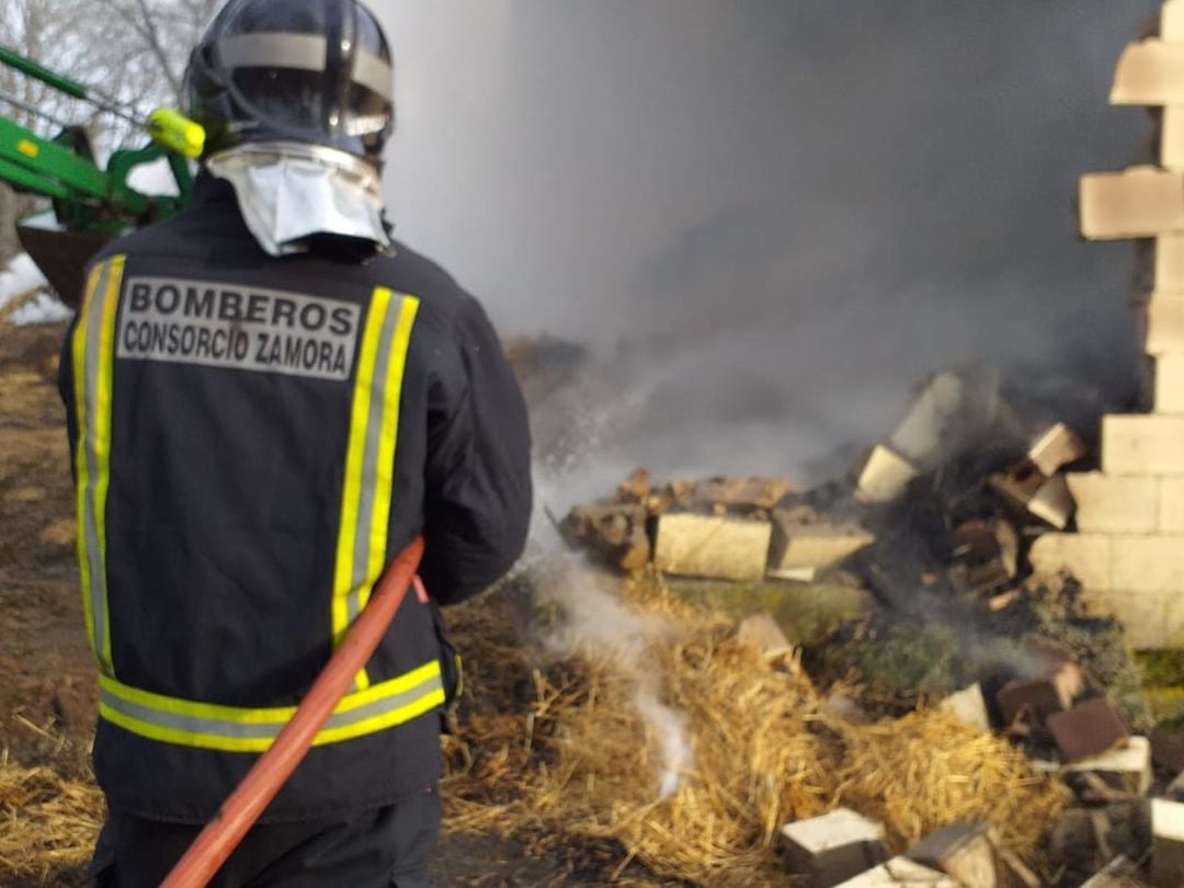 Un bombero trabaja en la extinción del incendio de la nave ganadera