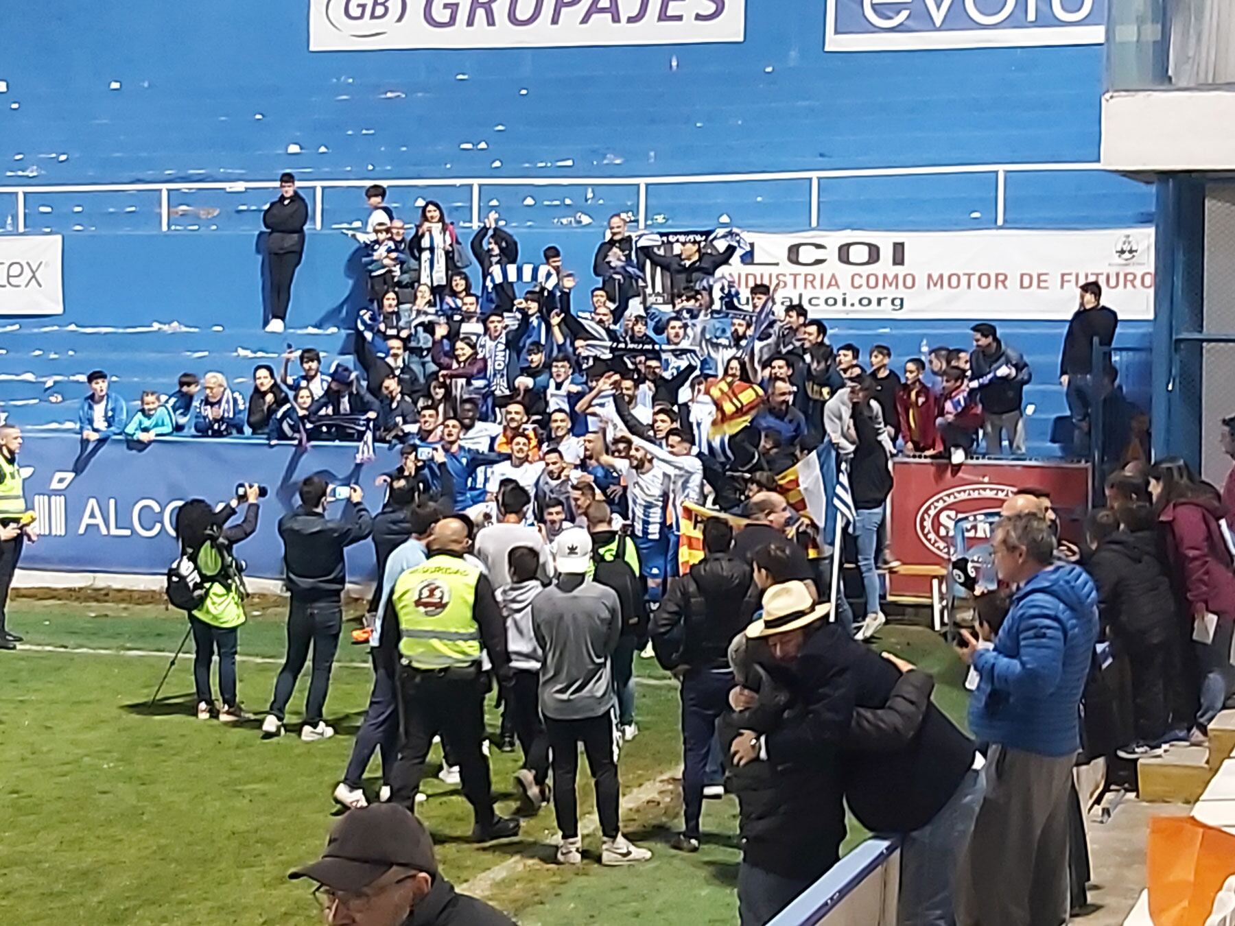 Los jugadores celebrando con una pequeña parte de la afición la permanencia y Vicente Parras en primer plano siendo abrazado