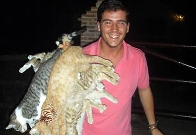 Uno de los dos miembros expulsados, posando sonriente con gatos muertos