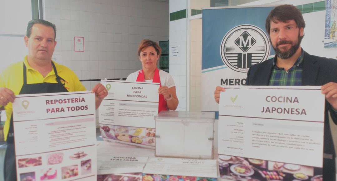 Representantes de la Asociación de comerciantes del Mercado de Peñamefécit y de la Asociación Gastronómica Santo Reino con los carteles de los cursos de cocina.