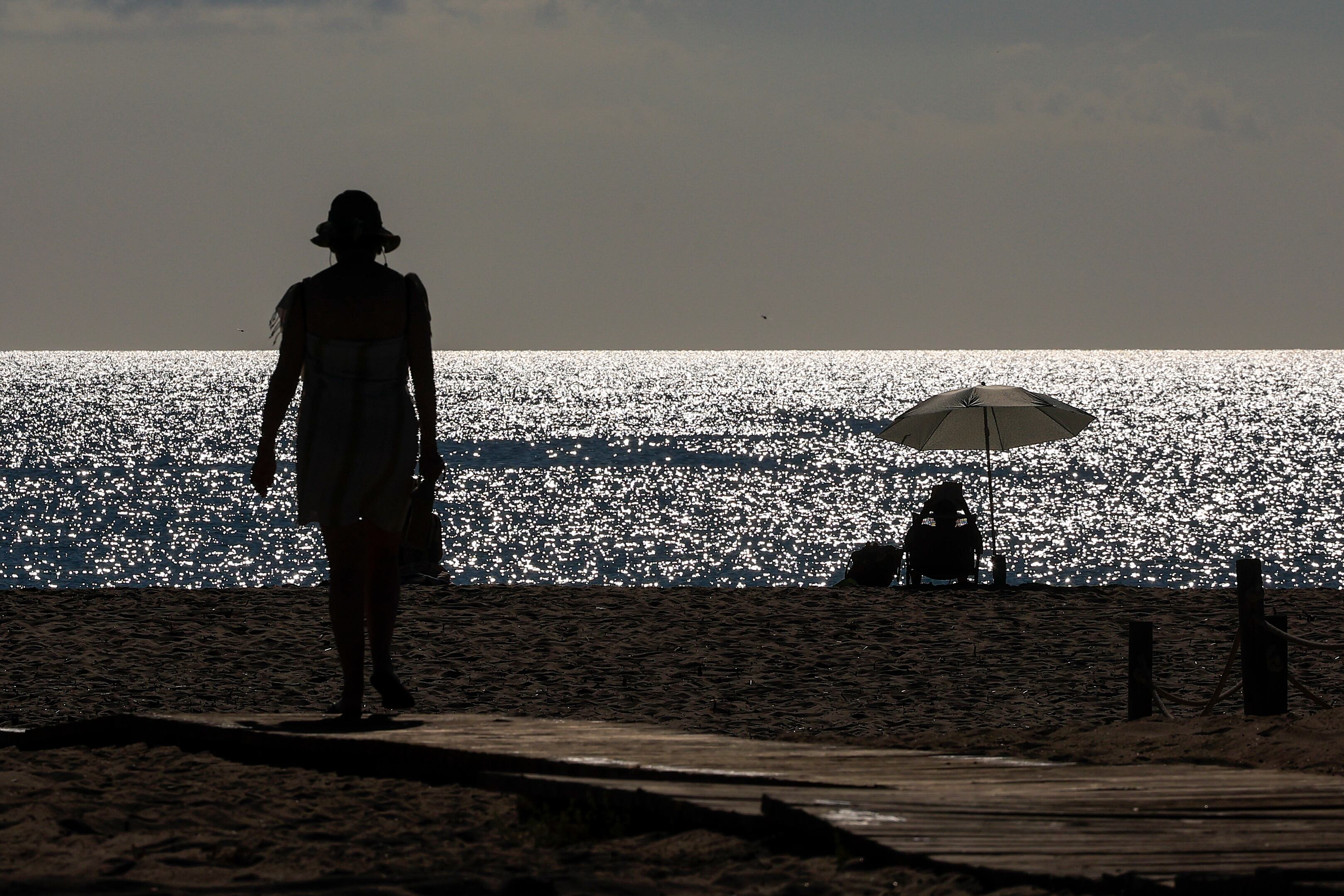 Dos personas disfrutan de la playa de El Saler durante este lunes en el que el cielo de la Comunitat Valenciana.