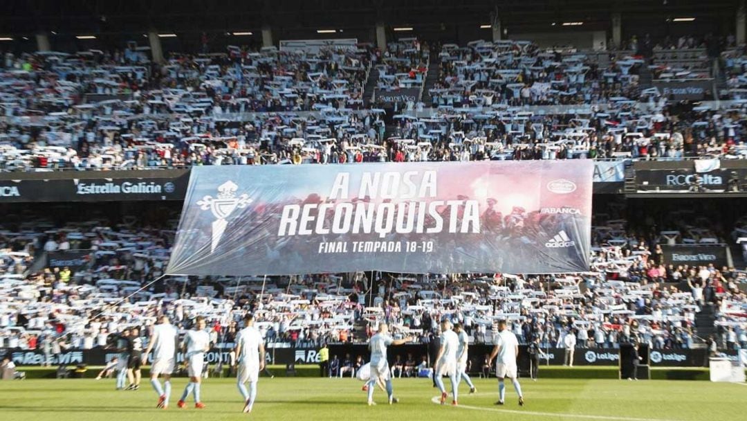 Jugadorres del Celta pasan delante del gran tifo desplegado por el celtismo en Balaídos apoyando al equipo