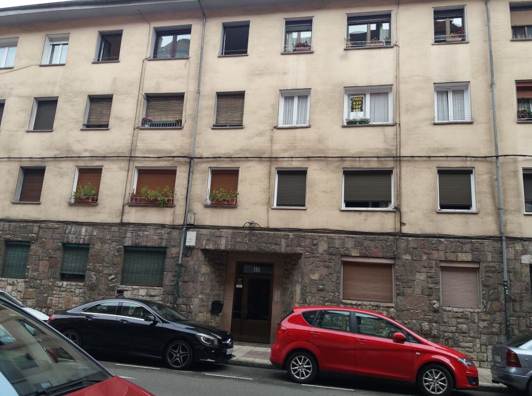 Edificio de la calle Río Narcea de Oviedo en el que vivía la mujer fallecida por inhalación de humo. A la derecha del portal, el número 17, se observaban esta mañana las dos ventanas de la vivienda, un bajo, con las persianas bajadas totalmente. Por una de esas ventanas entró su madre que fue la que la encontró tirada en el pasillo ya muerta.