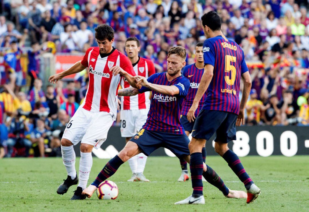 El centrocampista croata del FC Barcelona, Ivan Rakitic (c) junto al centrocampista Mikel San José (d), del Athletic Club de Bilbao, durante el partido de la séptima jornada de Liga que disputan en el Camp Nou de Barcelona