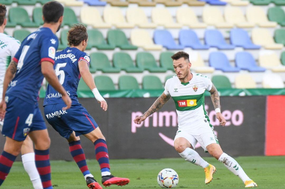 El jugador del Elche Josan trata de regatear a Mosquera