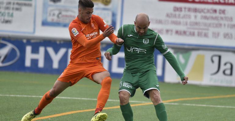 Óscar Quesada trata de mantener el balón ante la presión de un rival del Atlético Malagueño.