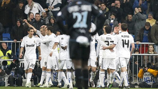 Los jugadores del Real Madrid celebran el primer gol del equipo, conseguido por el francés Karim Benzema (2i), durante el partido, correspondiente a la vigésimo sexta jornada de Liga de Primera División, que Real Madrid y Málaga CF disputan esta noche en 