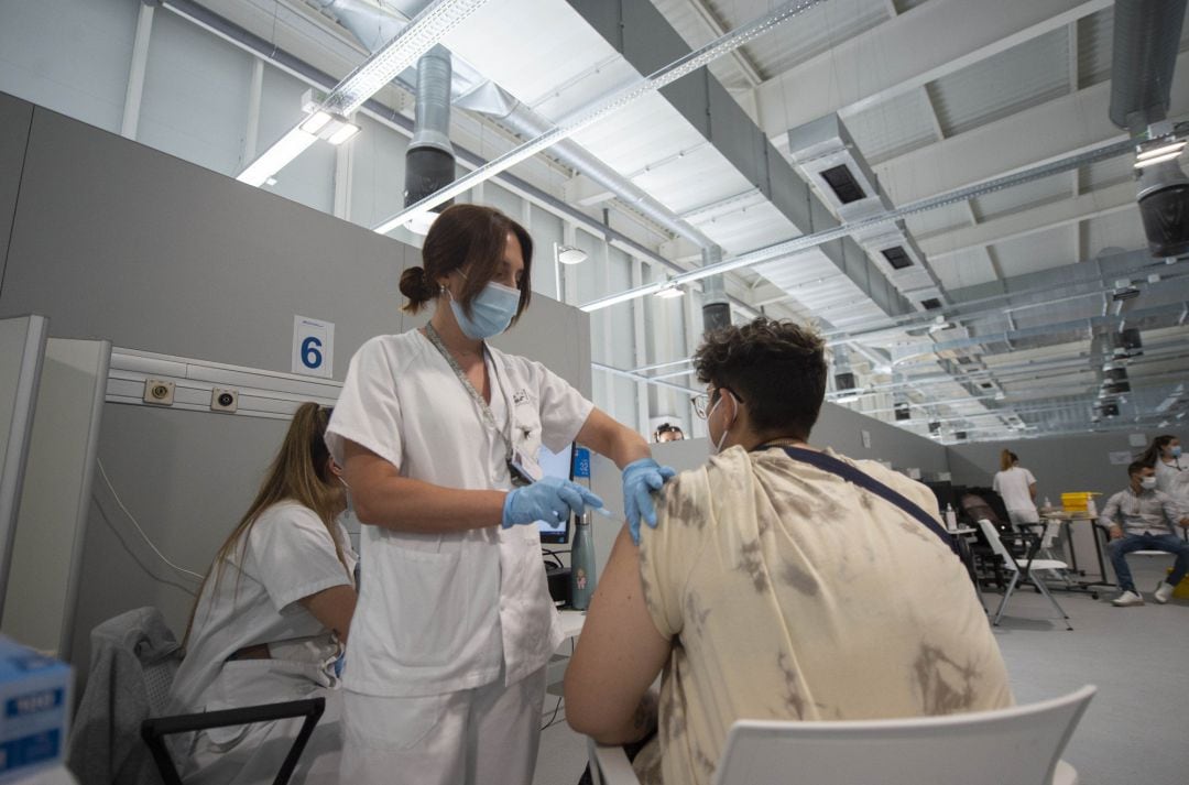 Un joven recibe la primera dosis de la vacuna en el Hospital Zendal de Madrid