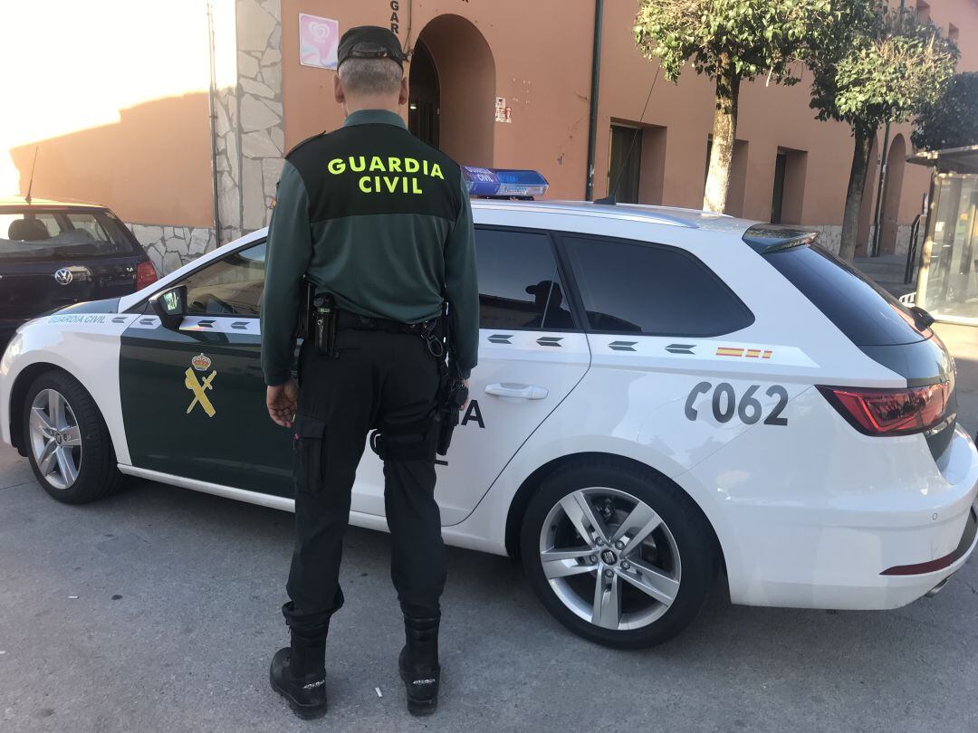 Un guardia civil y el coche patrulla