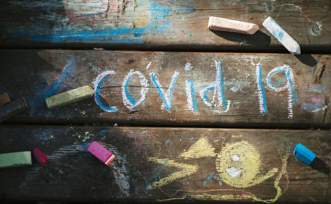 Los niños escriben con tiza la enfermedad que está condiconando su curso escolar