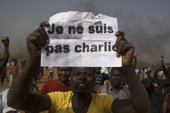 A man holds a sign during a protest against Niger President Mahamadou Issoufou&#039;s attendance last week at a Paris rally in support of French satirical weekly Charlie Hebdo, which featured a cartoon of the Prophet Mohammad as the cover of its first edition 