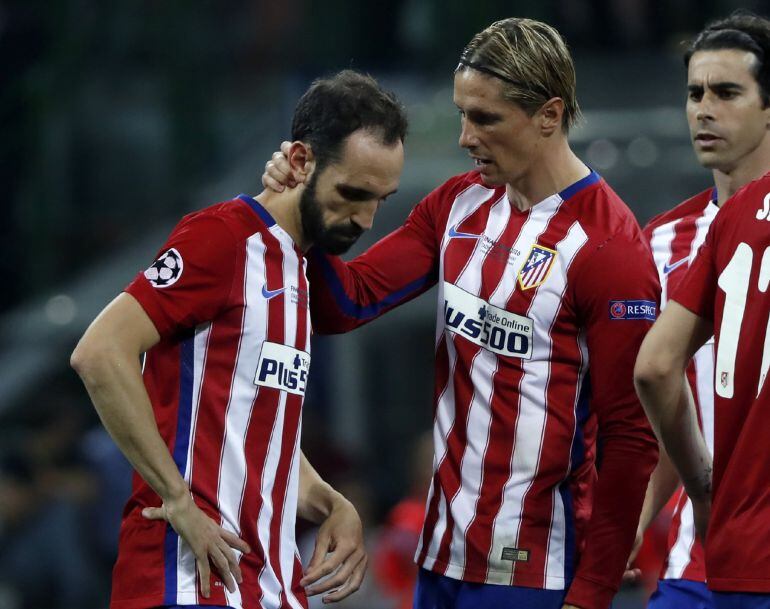 El defensa del Atlético de Madrid Juanfran es consolado por Fernando Torres tras fallar su penalti durante la final de Liga de Campeones que se disputa hoy contra el Real Madrid en el estadio de San Siro, en Milán. EFE/Ballesteros