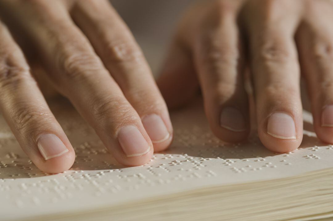 Uns mans llegint un llibre a l&#039;alfabet Braille.