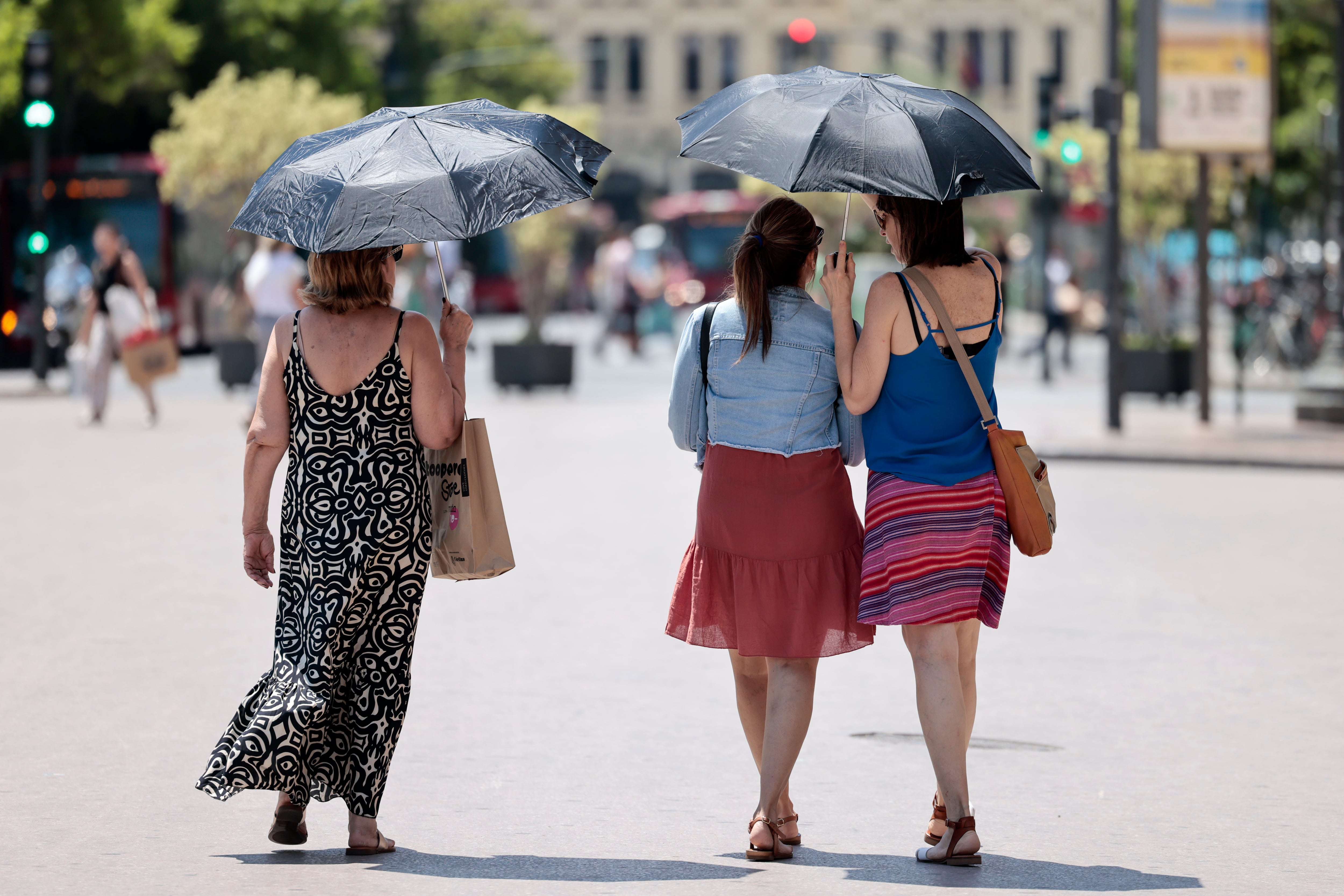 Varias personas refugiándose del calor en el centro de València