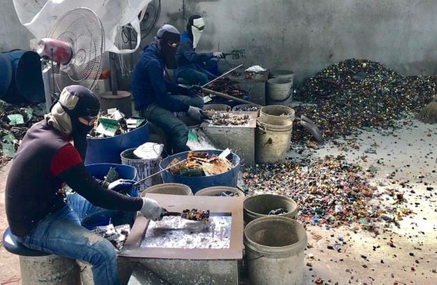 Burmese workers trying to protect themselves from the fume and smoke from the cooking of circuit boards in a primitive site in Thailand receiving e-waste from North America and Europe