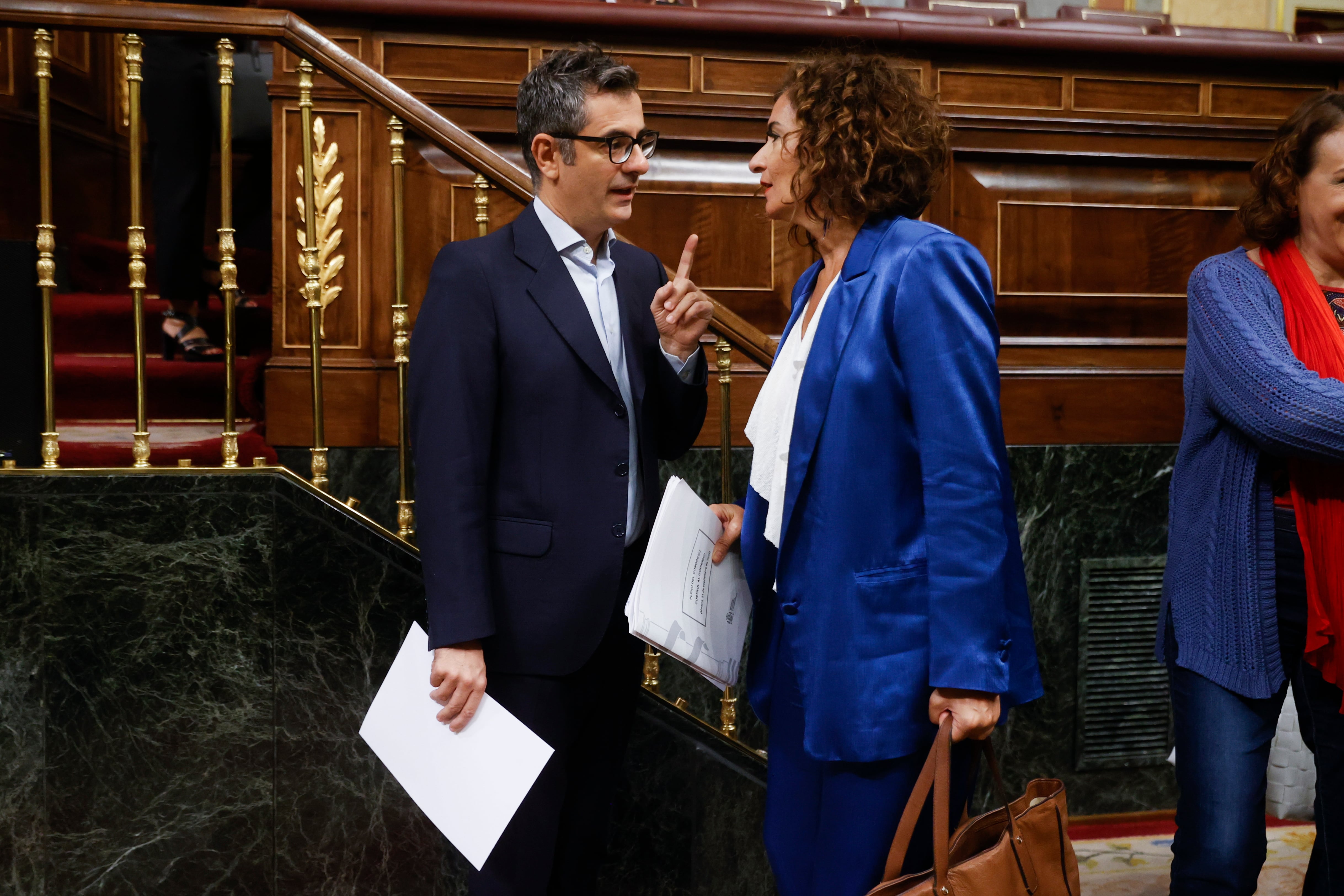 El ministro de Presidencia, Félix Bolaños (i), conversa con la ministra de Hacienda, María Jesús Montero (d), interviene durante la sesión de control en el Congreso de los diputados este miércoles, en Madrid.