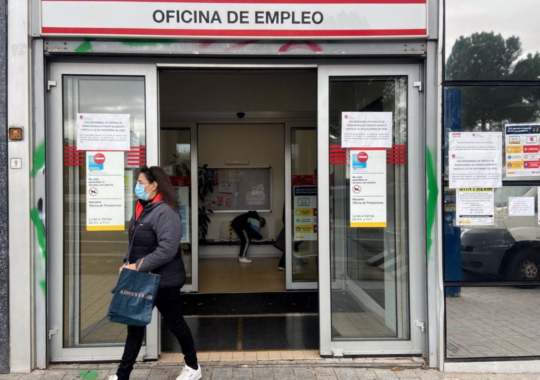 Una mujer sale de una oficina de empleo