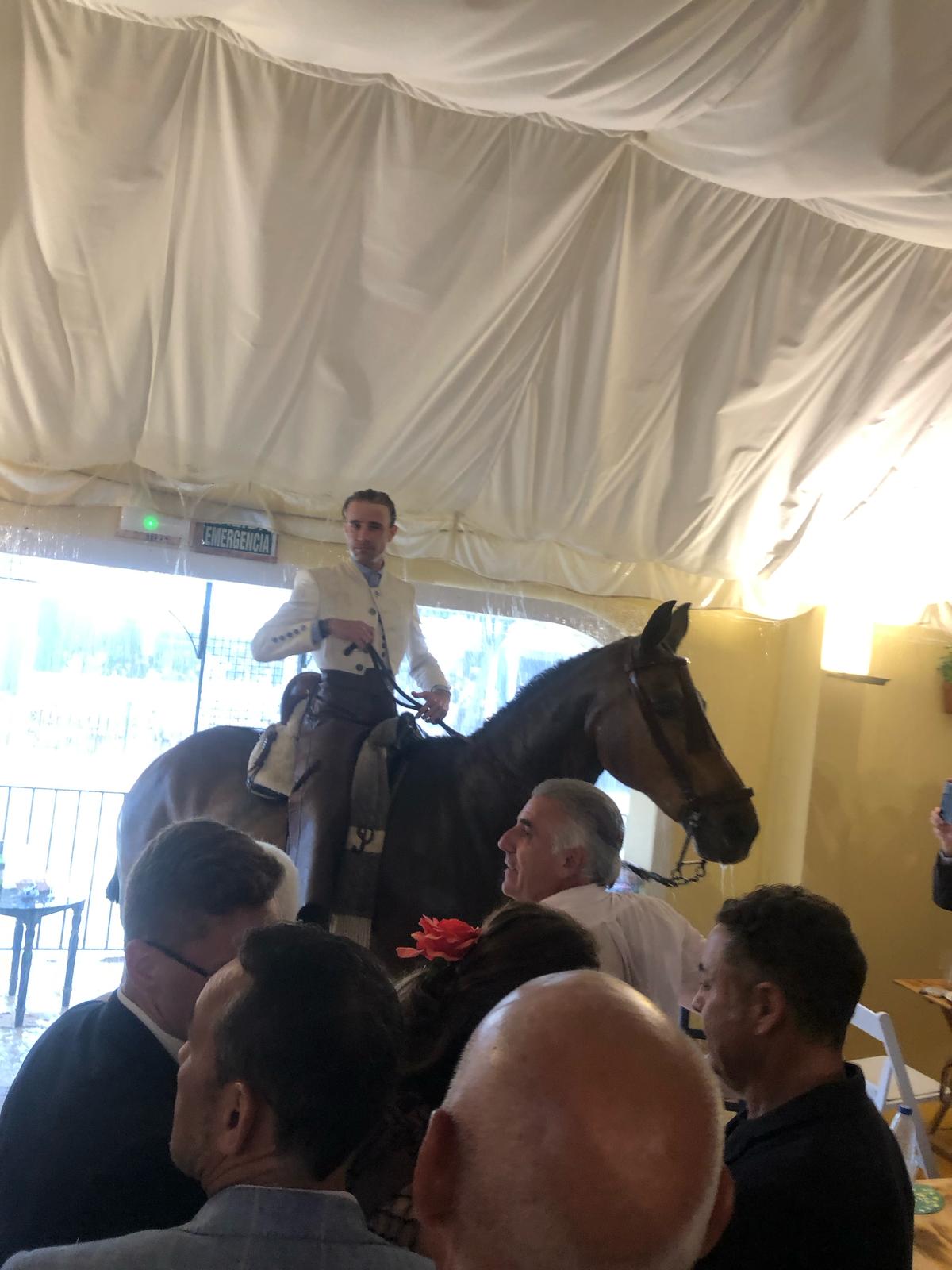 Un caballista en el interior de una caseta para resguardarse de la lluvia