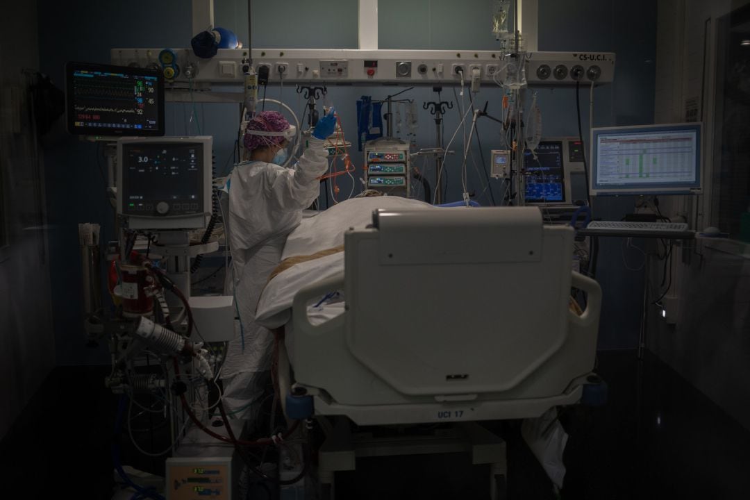 Trabajadores sanitarios protegidos atienden a un paciente en la UCI del Hospital del Mar, en Barcelona