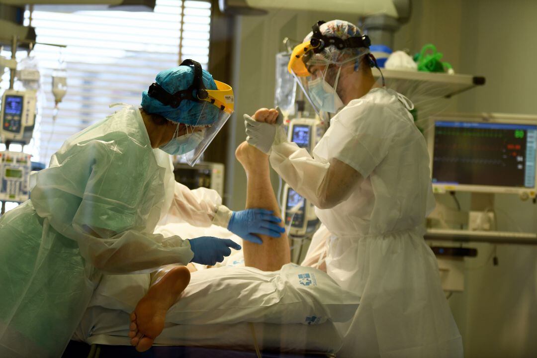 Personal sanitario con un paciente de COVID-19 en la UCI. 