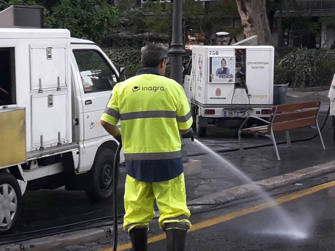 Un operario de la empresa INAGRA baldea una calle de Granada en tareas de limpieza urbana