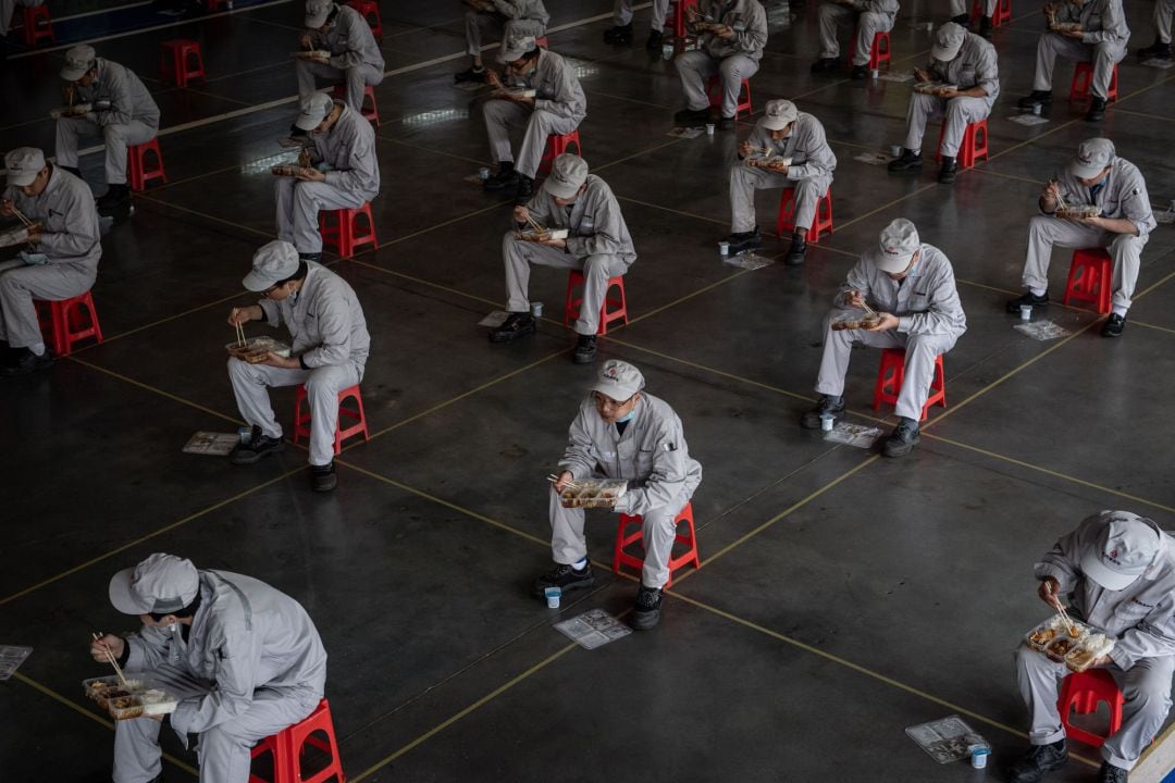 Trabajadores de una industra de Wuhan durante la comida y separados un metro y medio de distancia. 