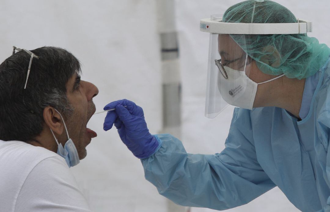 Una sanitaria realiza un frotis bucal para realizar un test de coronavirus 