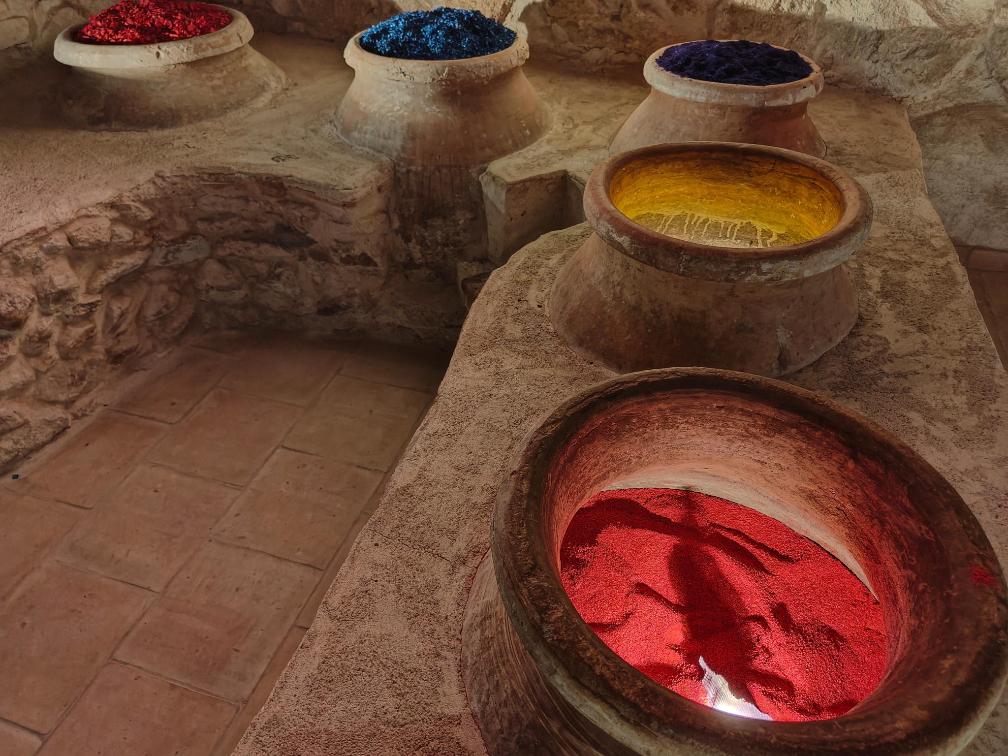 Unas tinajas recogen serrín tintado en el Museo de las Alfombras de Serrín