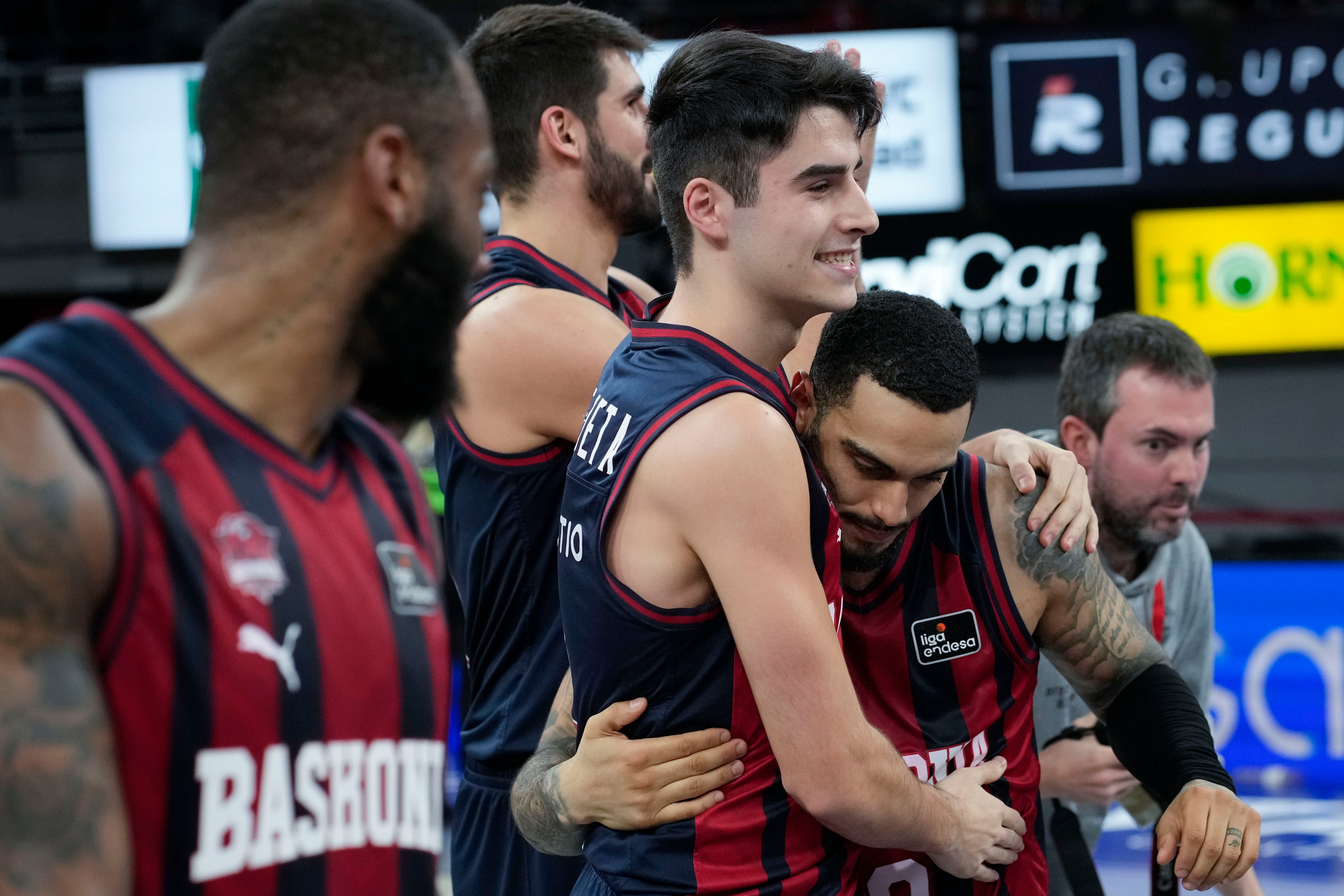 Marcus Howard (d) se abraza a su compalero, Joseba Querejeta (i) tras ganar el partido y batir su récord de 10 triples en un partido tras el encuentro contra el Coviran Granada de Liga Endesa disputado en el Fernando Buesa Arena de Vitoria-Gasteiz. EFE/ ADRIÁN RUIZ HIERRO