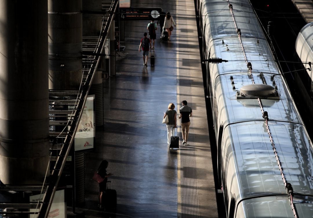 Viajeros caminan por uno de los andenes de la estación de tren Madrid Puerta de Atocha.