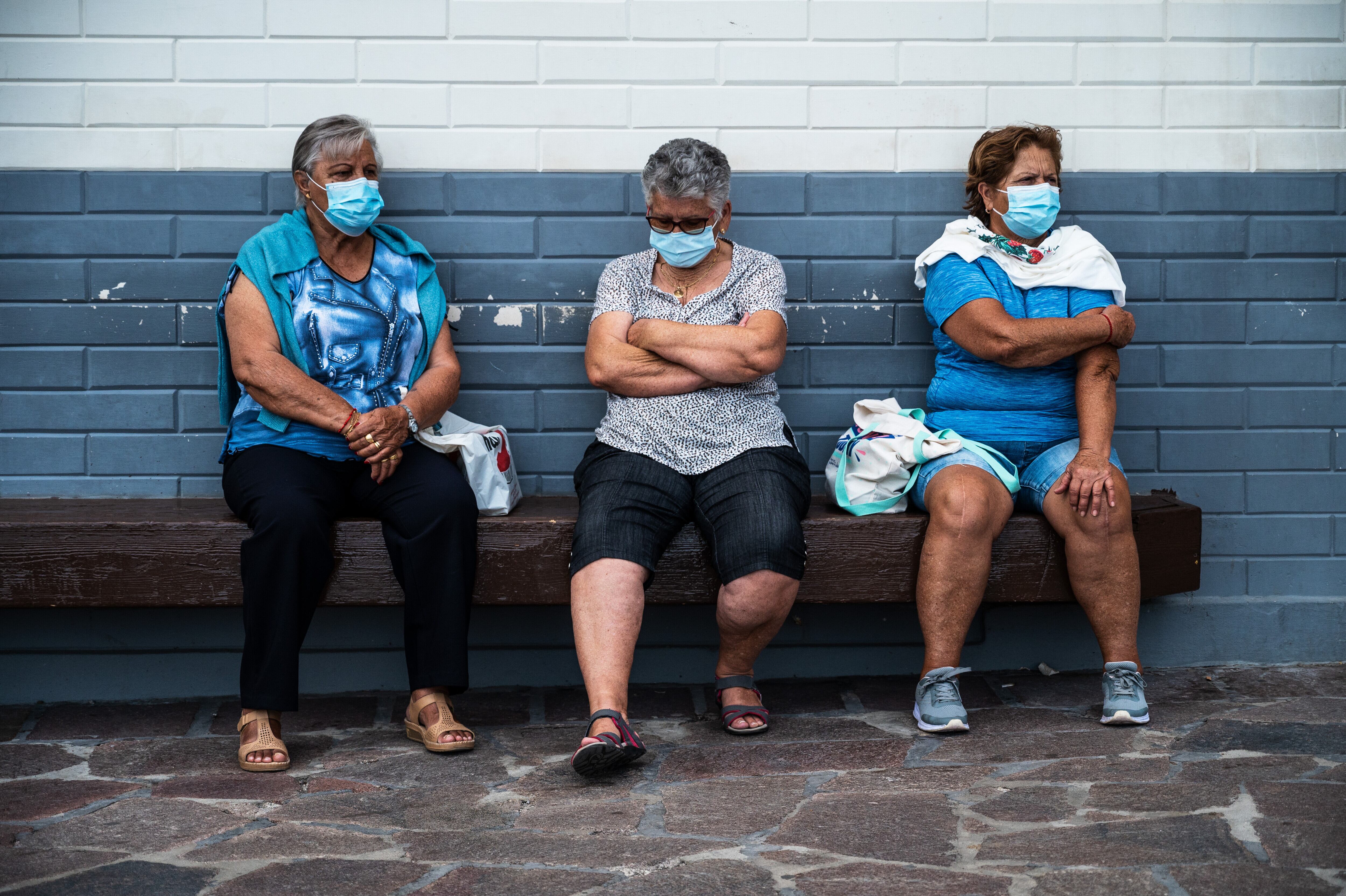 Tres mujeres descansan en un banco con sus mascarillas para prevenir un posible contagio por covid-19.