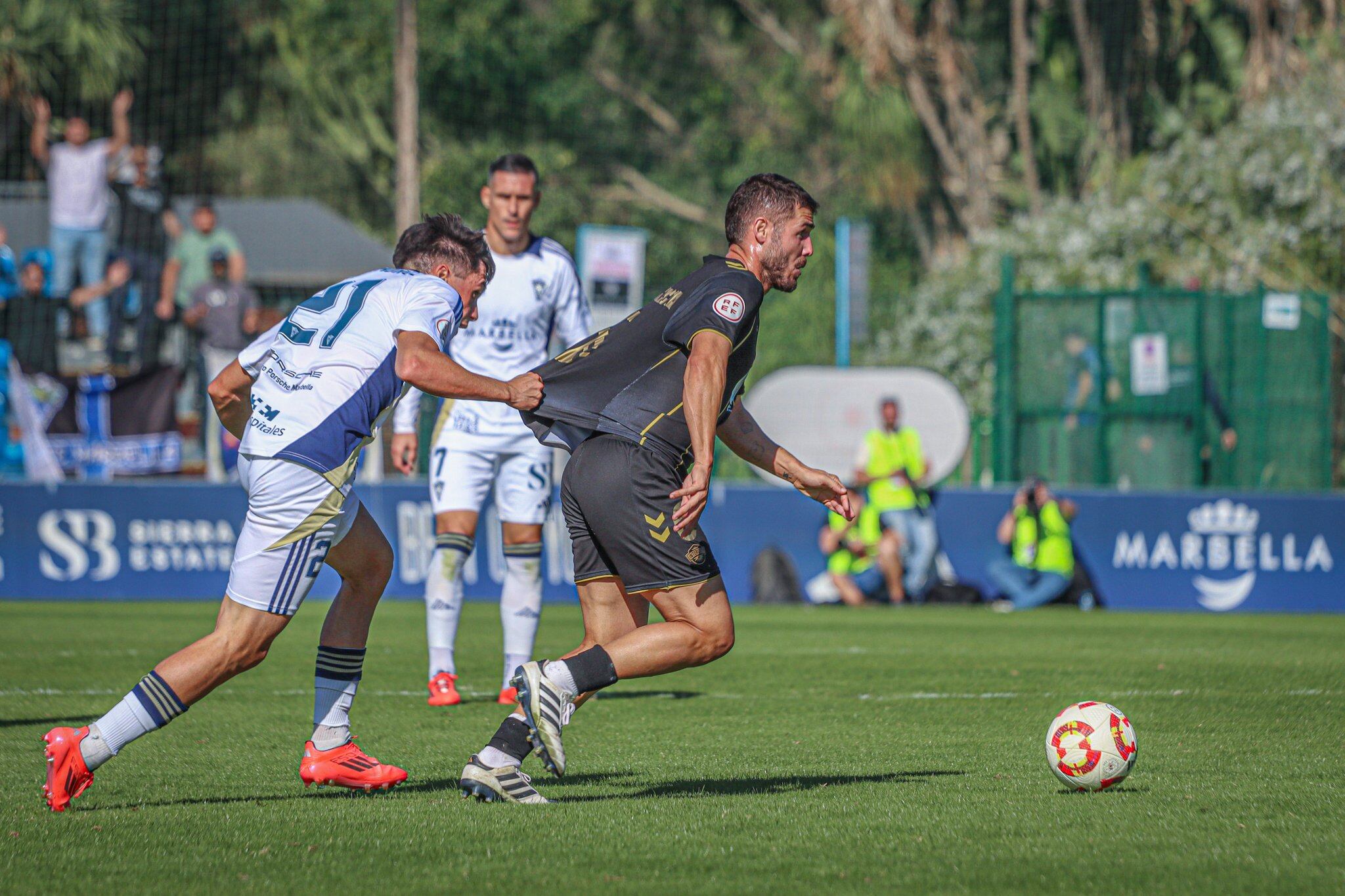 Pablo Muñoz, jugador del Marbella, agarra a un jugador del Intercity