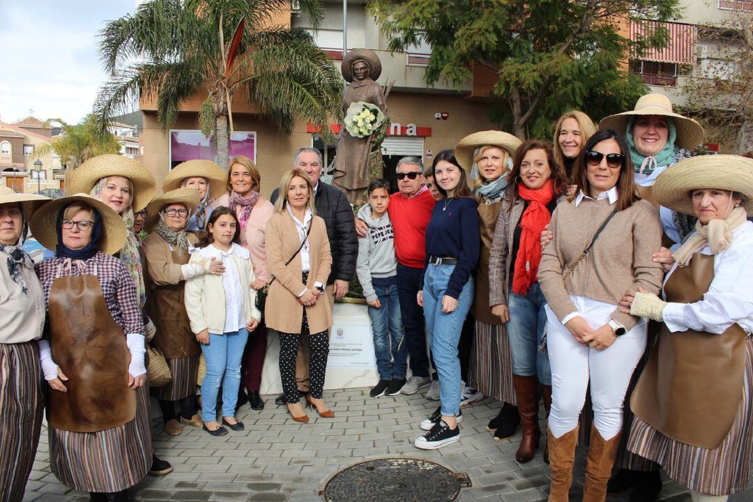 La alcaldesa de Motril, Luisa García Chamorro, junto con miembros del equipo de gobierno, la comparsa "Las Chicas de Oro" y familia de Adela Muñoz durante el descubrimiento de la placa homenaje en la rotonda de la Mondera