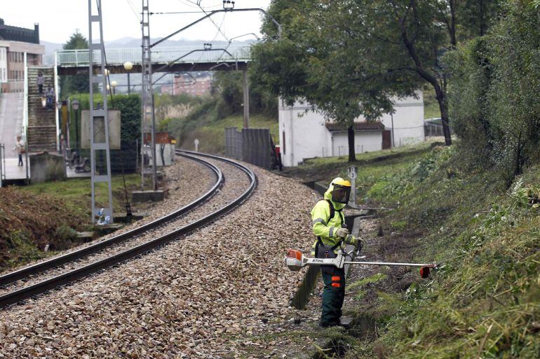 Miembros de la Policía buscan pruebas junto a la vía de tren en las inmediaciones del apeadero de La Argañosa, a las afueras de Oviedo