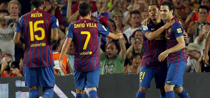 El centrocampista del F.C.Barcelona Cesc Fábregas (d) recibe la felicitación de sus compañeros Adriano Correia (2d), David Villa (2i) y Seydou Keita tras lograr el primer gol de su equipo ante el Nápoles, en el Trofeo Joan Gamper