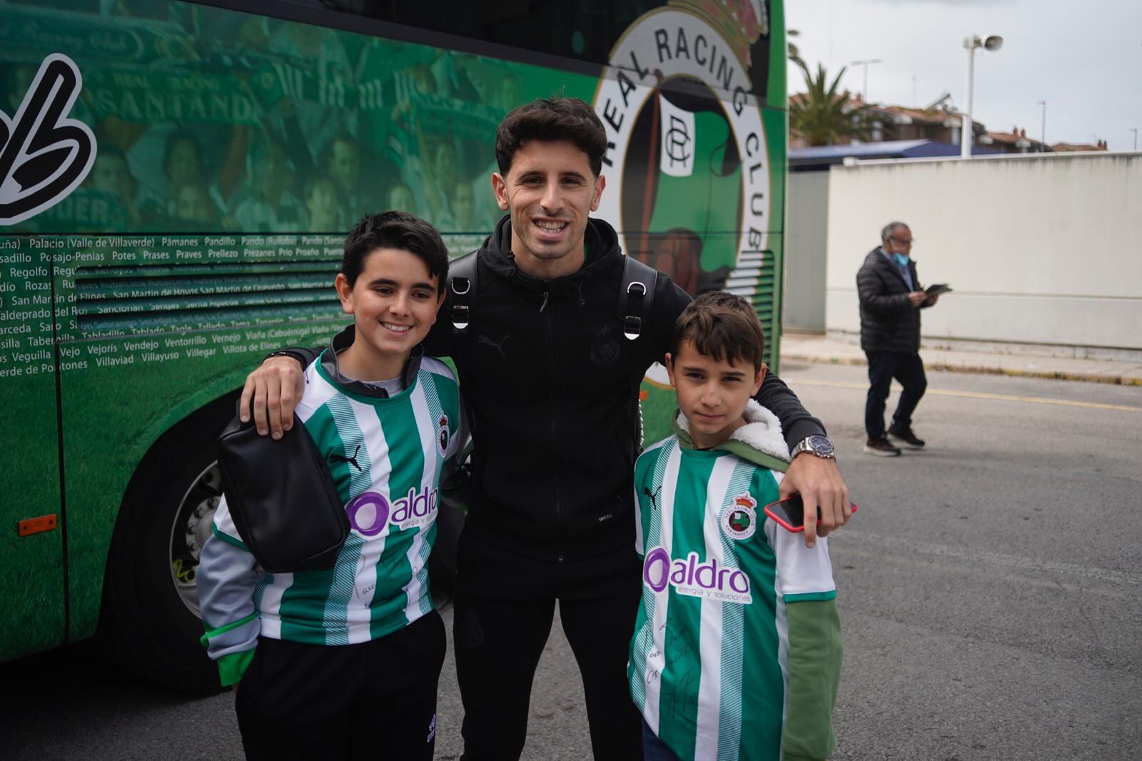 Marco Camus posa con dos niños que llevan la primera camiseta del Racing de la temporada actual
