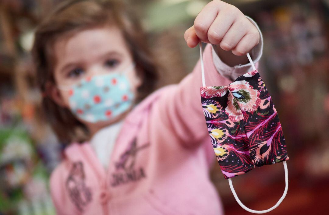 Una niña muestra una mascarilla infantil mientras sale a la calle en Pamplona a finales de abril.