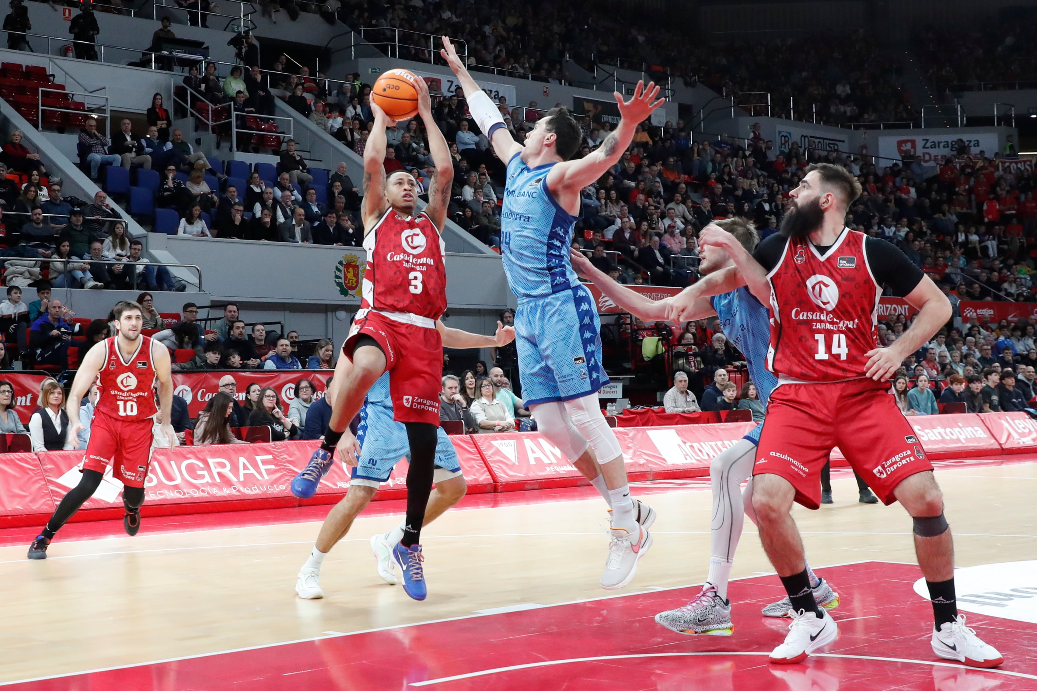 L&#039;escorta del Casademont Zaragoza AJ Slaughter (2i) intenta encistellar durant el partit corresponent a la jornada 18 de la Lliga Endesa, aquest diumenge, al pavelló Príncipe Felipe a Saragossa.