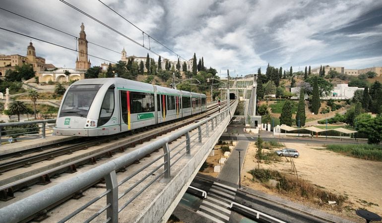 El Metro, a su paso por la pasarela sobre la SE-30 con San Juan de Aznalfarache al fondo