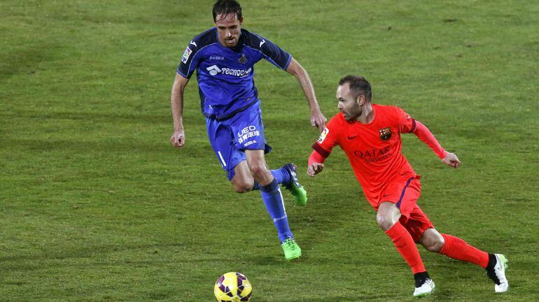 El centrocampista del Barcelona Andrés Iniesta (d) controla el balón ante el centrocampista del Getafe Míchel Herrero en el partido de la decimoquinta jornada de liga en Primera División que se disputa en el Coliseo Alfonso Pérez
